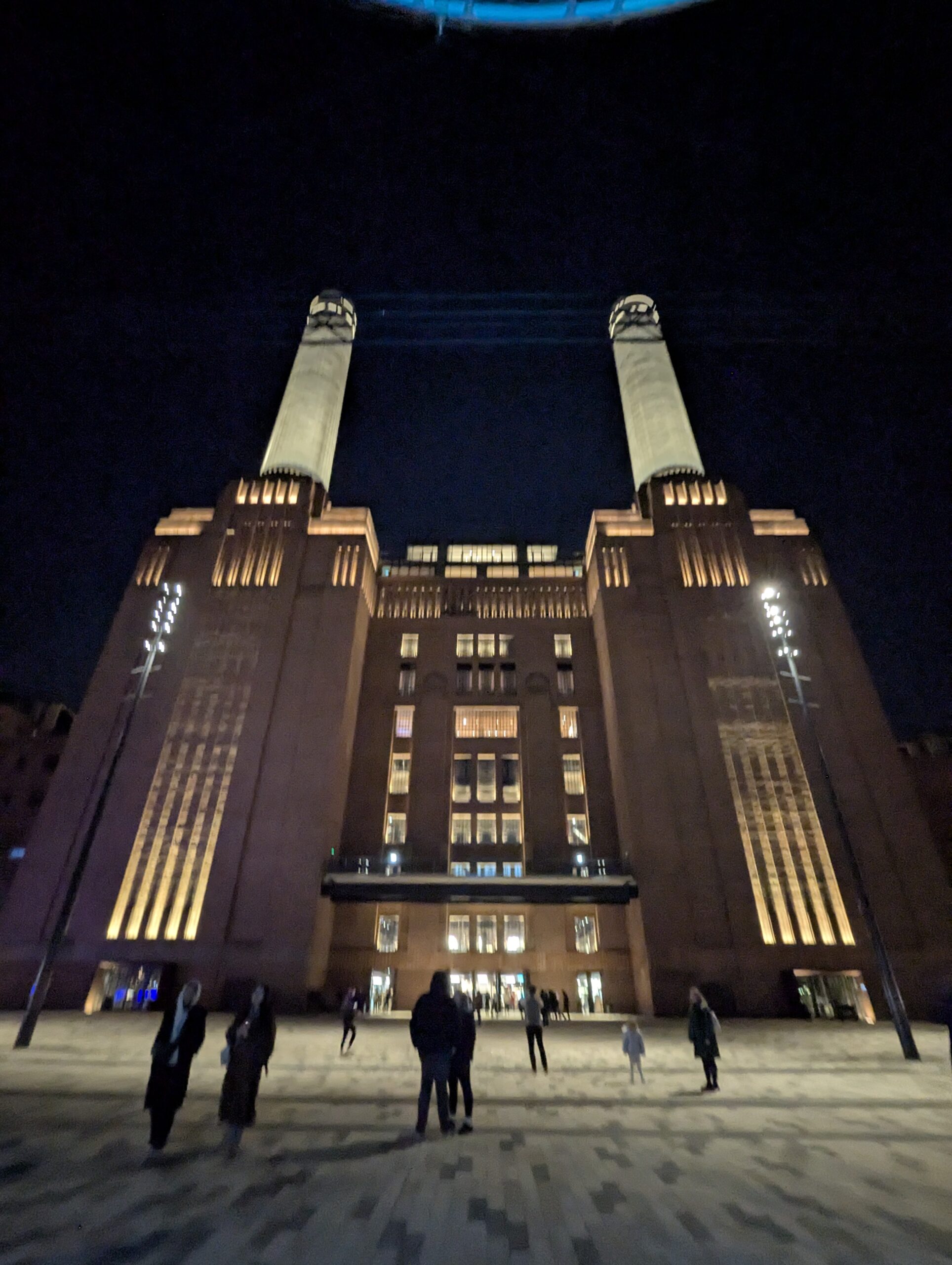 Battersea Power Station viewed from the front at night, showing strong approximate bilateral symmetry